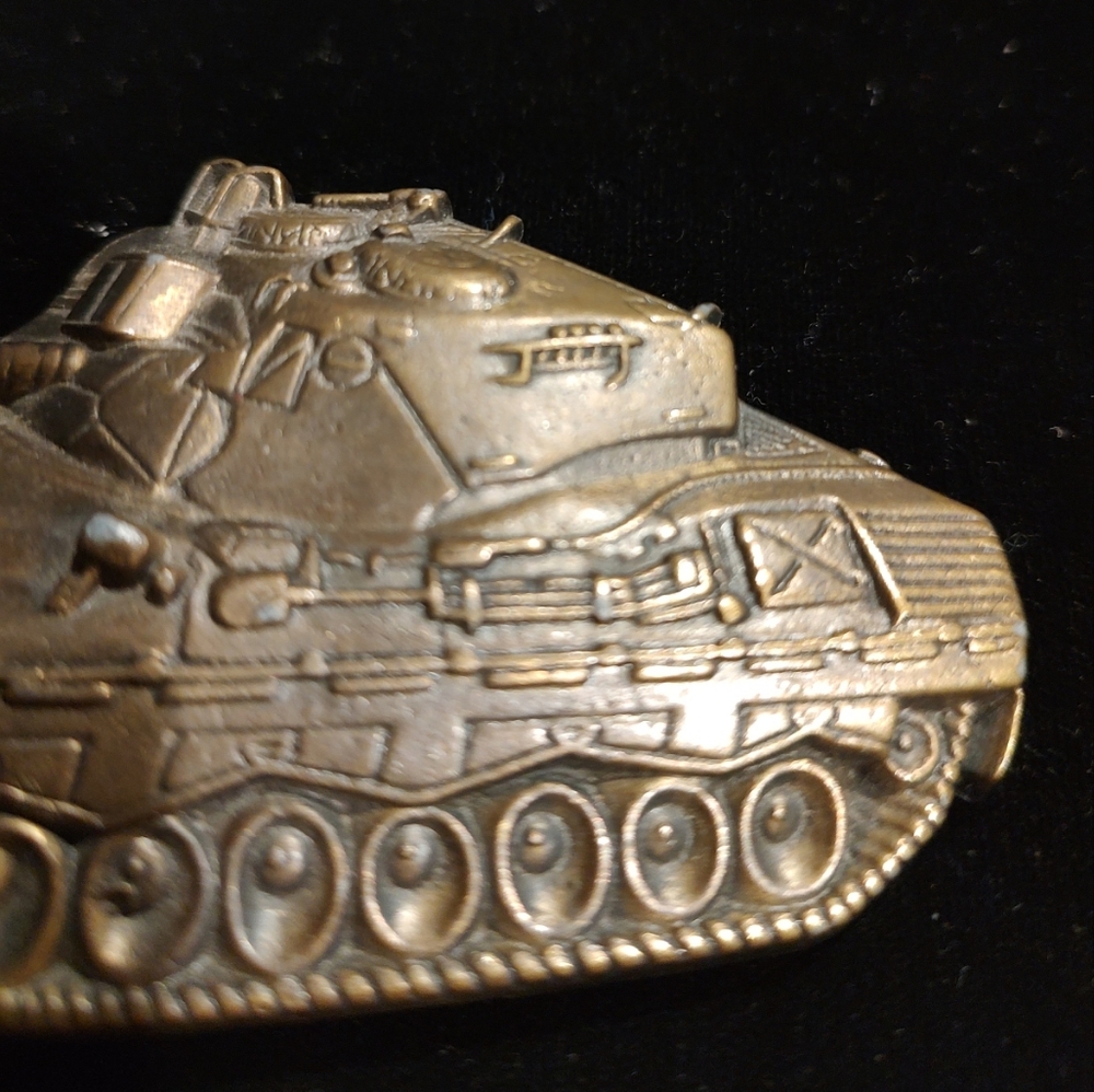 Vintage belt buckle features a detailed military tank cut-out design in brass